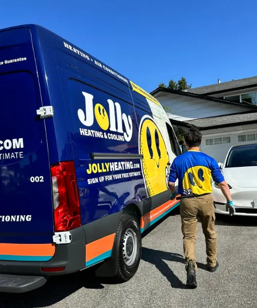 Jolly Heating & Cooling technician walking to a branded service van